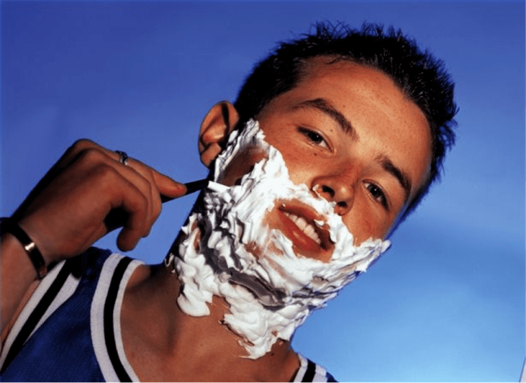 тинејџер се брије и размишља о повећању пениса